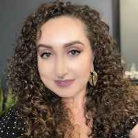 a woman with curly hair is posing for a photo